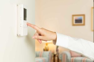 Homeowner adjusting thermostat as part of Byrd Heating and Air HVAC winter preparation
